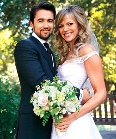 Rob McElhenney putting his arms around his wife Kaitlin Olson in their wedding dresses.
